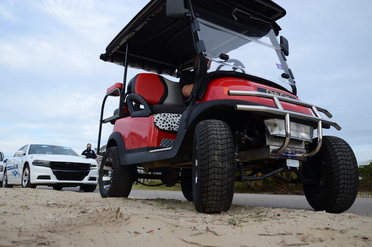 Golf cart in front of a police cruiser