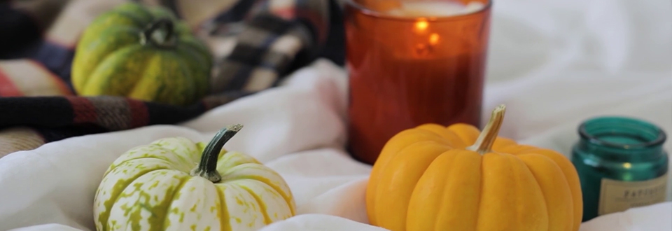 Thanksgiving 2020 banner shows 2 small pumpkins and a candle